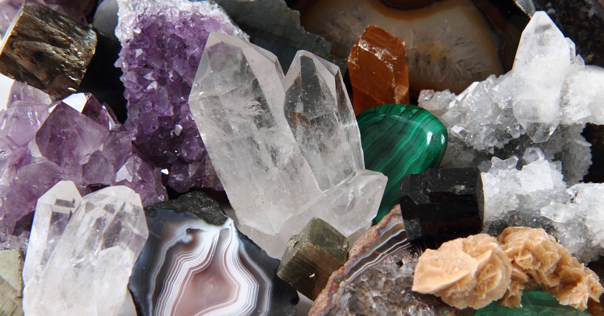 A pile of gemstones, including amethyst, selenite, jasper, jade, and tiger's eye. They're gathered on top of each other.
